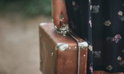 girl in a vintage dress holding a vintage suitcase